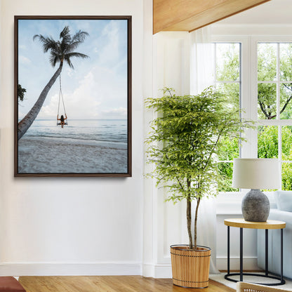 Wall art of a girl on a swing hanging from a palm tree over calm ocean waters, perfect for tropical or minimalist coastal decor.