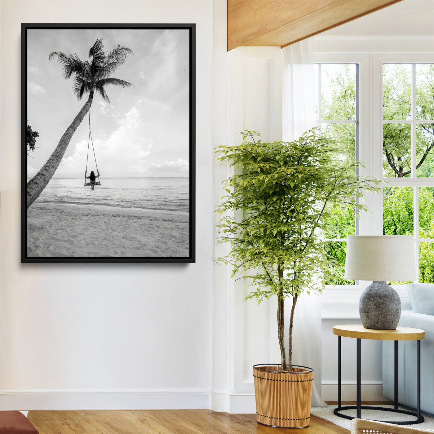 Monochrome photo of a woman swinging from a palm tree on a serene beach, ideal for minimalist or tropical coastal decor.