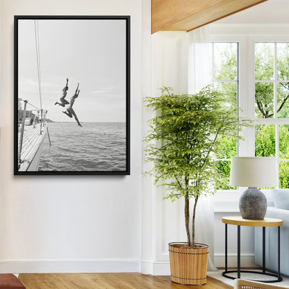 Black and white canvas wall art of two women joyfully jumping off a yacht into the sea, ideal for minimalist coastal or nautical-themed spaces.
