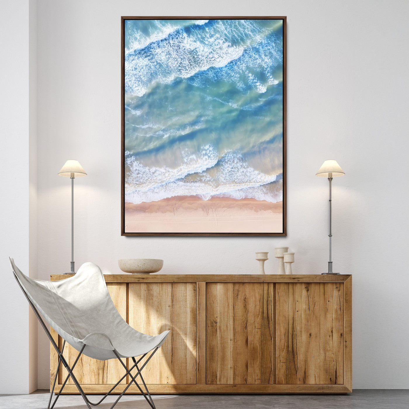 Aerial photo of soft blue waves meeting sandy shore, perfect for modern coastal or beach-themed decor with a light and tranquil aesthetic.