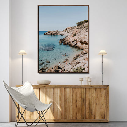 A vibrant coastal photo of a rocky Mediterranean cove with turquoise waters and beachgoers, ideal for boho coastal or summer-inspired interiors.