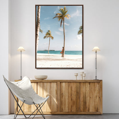 Person leaning on a palm tree at a tropical beach with white sand and turquoise water, perfect for coastal or beach-themed home decor.