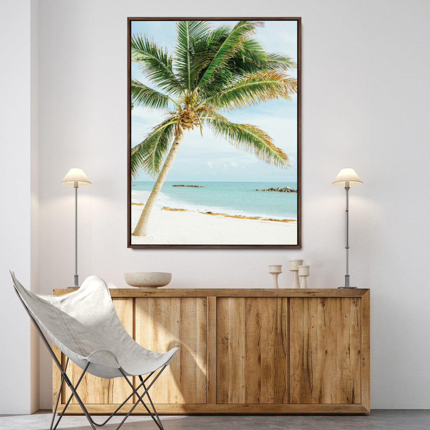 A tall palm tree leaning over a white sandy beach with turquoise ocean waves, creating a peaceful and tropical coastal scene.
