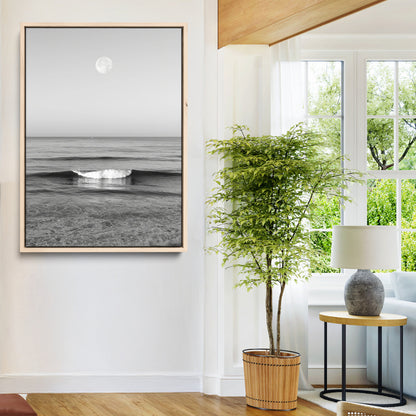Black and white wall art of a calm ocean wave beneath a full moon, ideal for minimalist or monochrome coastal decor.