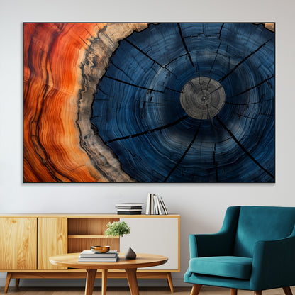A captivating close-up of a tree trunk, showcasing its concentric rings in rich shades of blue, orange, and brown, highlighting the organic patterns of natural wood.