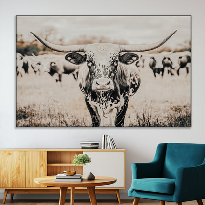 Canvas of a speckled Texas longhorn standing boldly in a field with a herd behind, perfect for rustic western or farmhouse wall decor.