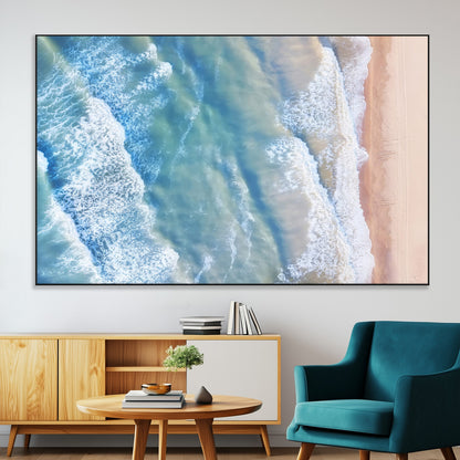 Aerial photo of soft blue waves meeting sandy shore, perfect for modern coastal or beach-themed decor with a light and tranquil aesthetic.