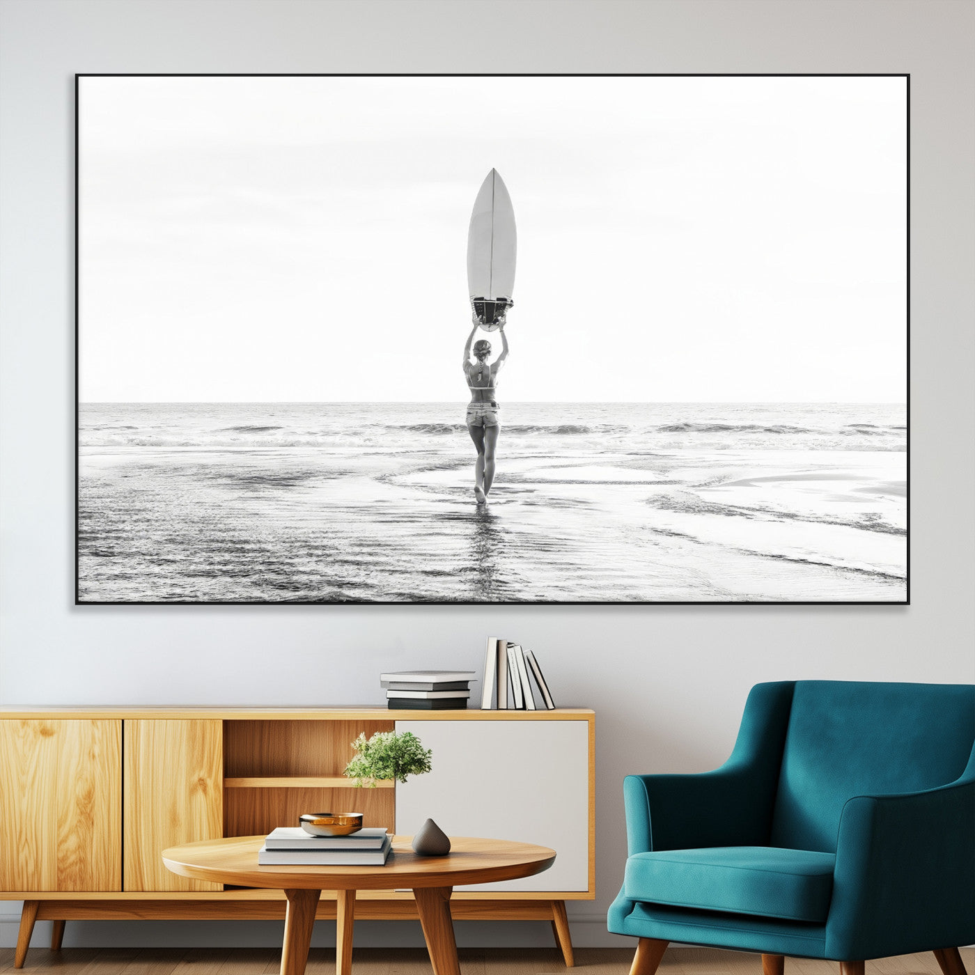 Black and white image of a female surfer holding a surfboard above her head while walking toward the ocean, creating a minimalist and bold coastal aesthetic.