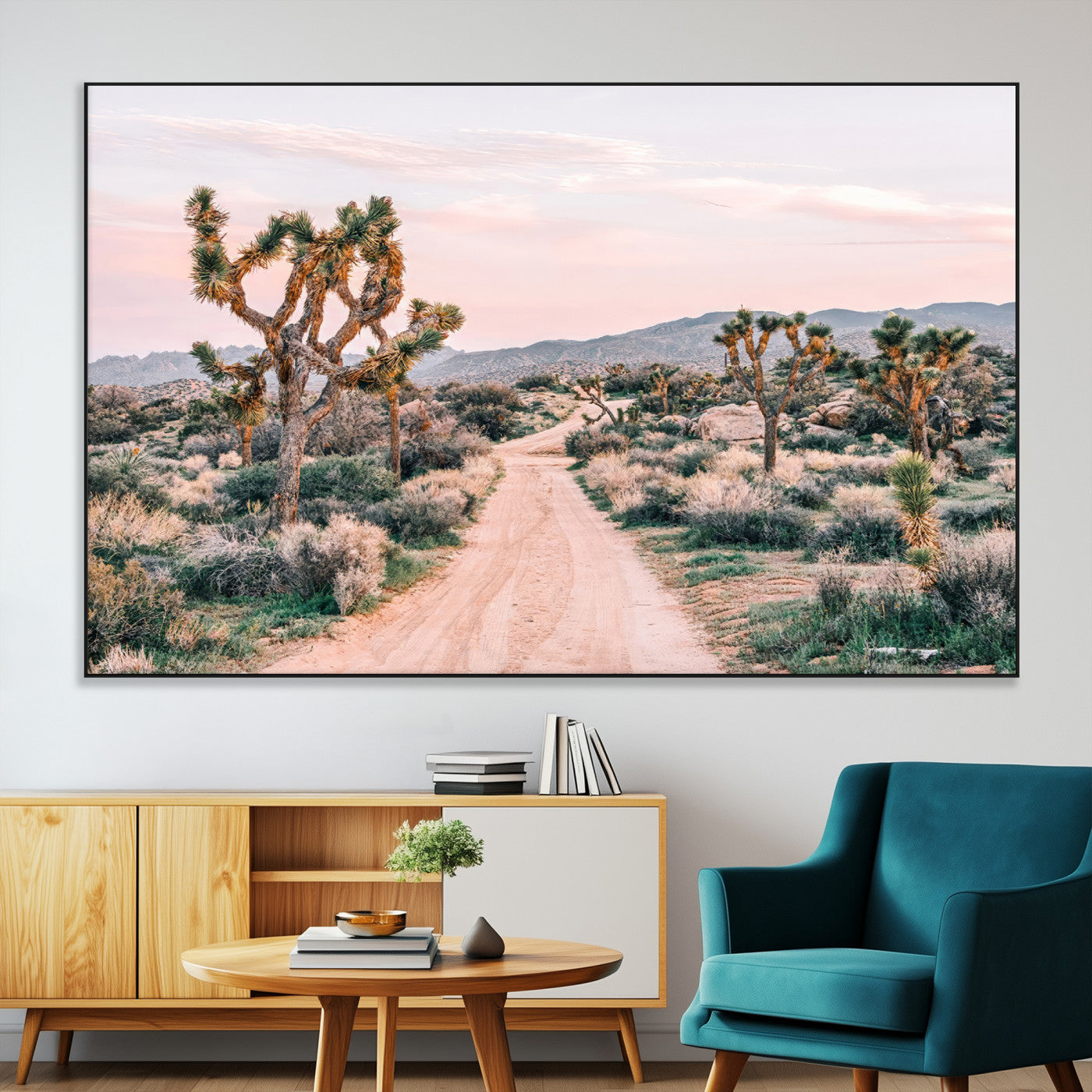A dusty road winding through Joshua Tree National Park, framed by iconic twisted trees and warm desert tones under a soft pastel sky.