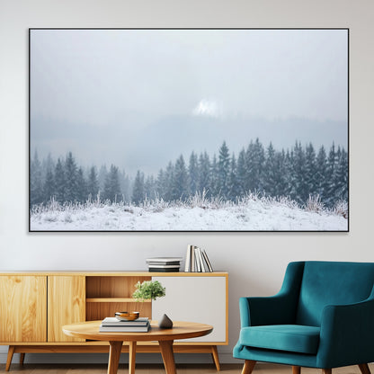 Snow-covered forest under misty sky, soft light breaking through clouds, ideal for minimalist or Nordic-inspired home decor.