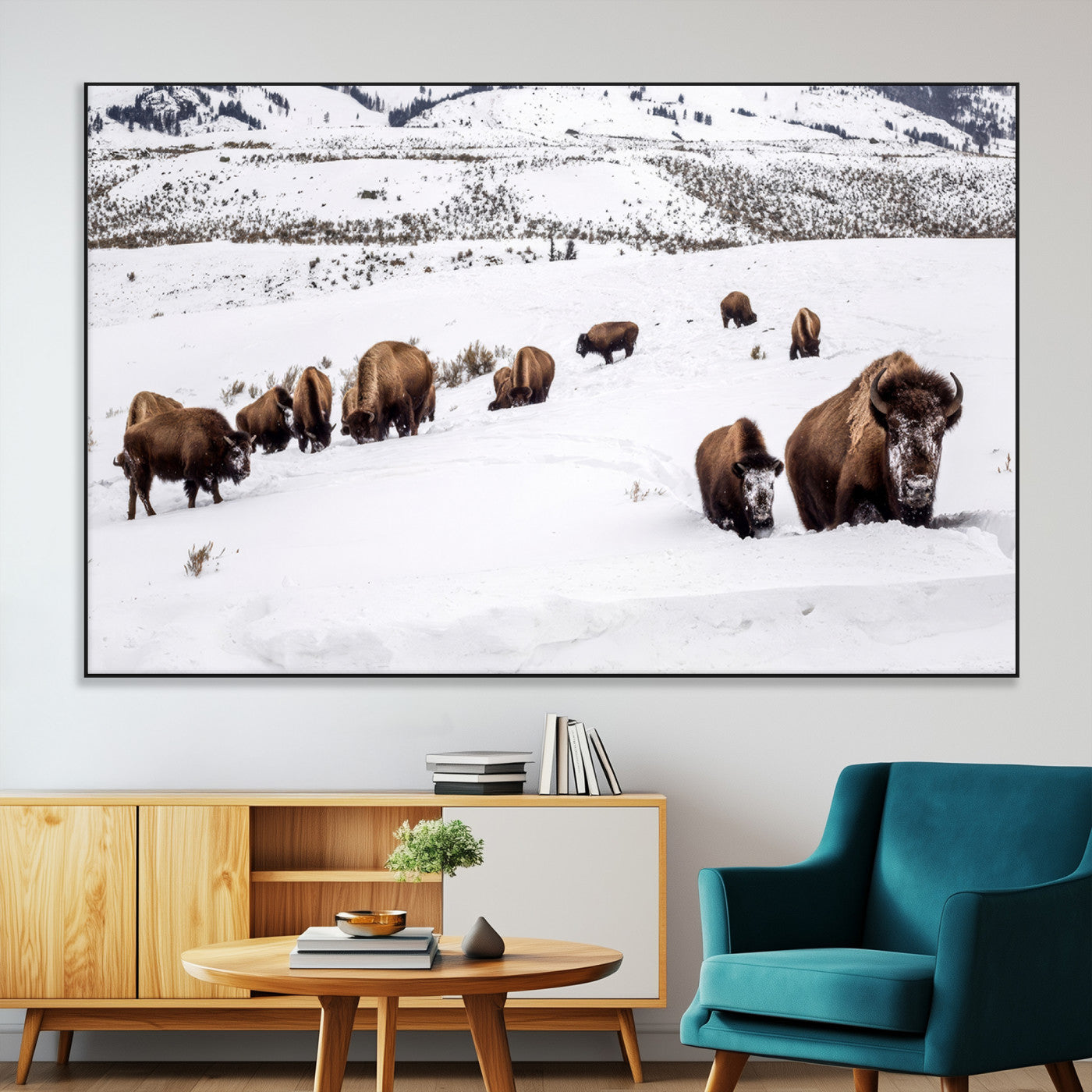 A herd of bison walking through deep snow in a mountain valley, perfect for rustic, cabin or western-themed wall decor.