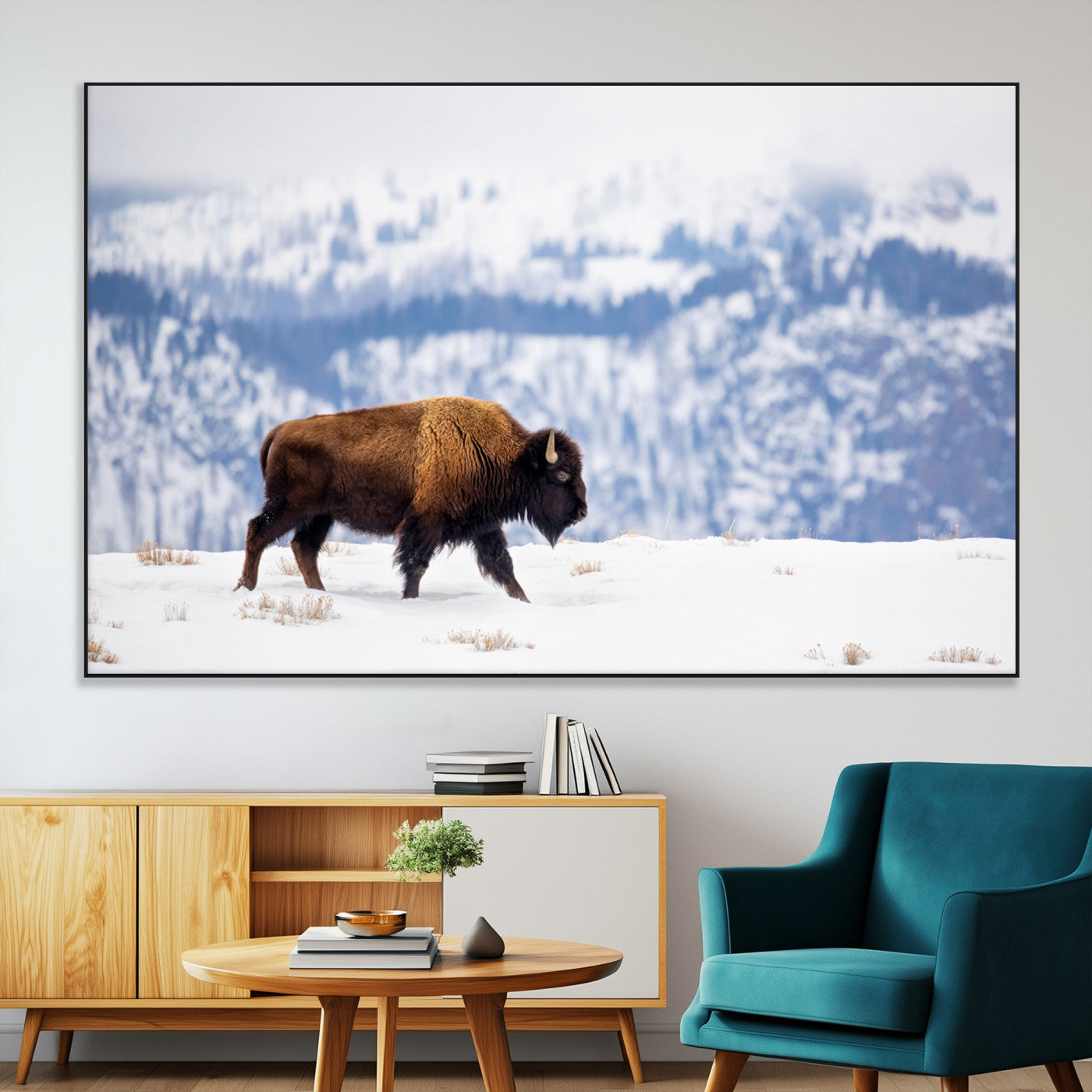 A lone bison walks across snowy ground with blue-toned mountain range behind, ideal for rustic or western farmhouse interiors.