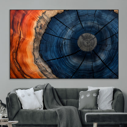 A captivating close-up of a tree trunk, showcasing its concentric rings in rich shades of blue, orange, and brown, highlighting the organic patterns of natural wood.