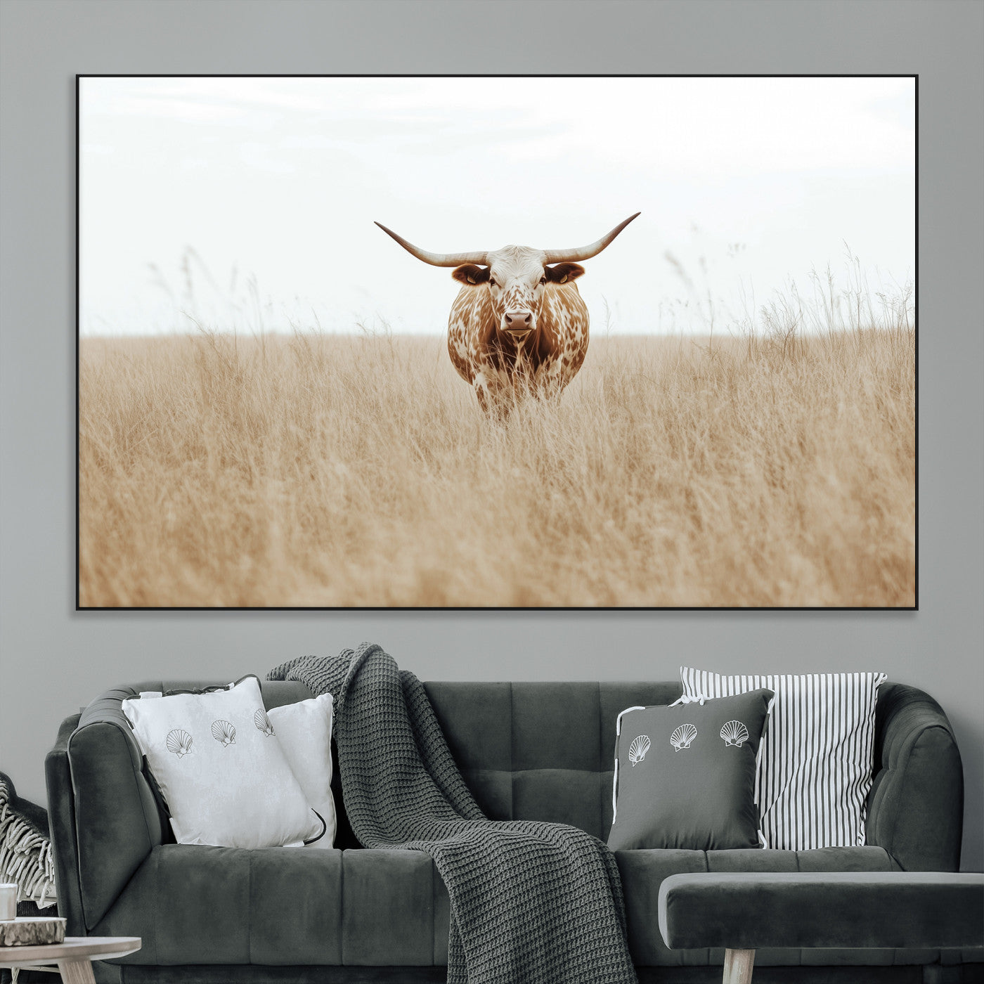 Texas Longhorn bull standing alone in dry grass with neutral tones, ideal for rustic western or cowboy-themed wall decor.