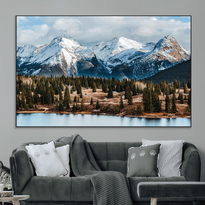 Framed canvas of snowy mountain peaks with pine forest and alpine lake, perfect for winter cabin or wilderness-inspired home decor.