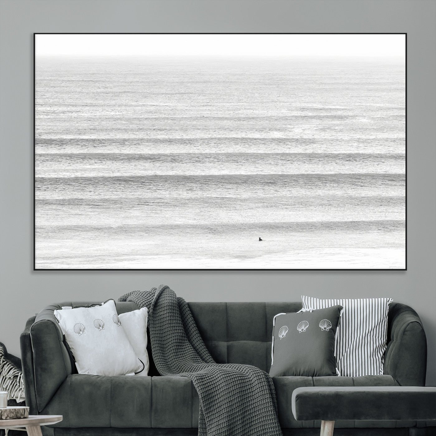 Monochrome photo of a lone surfer in calm layered waves, perfect for minimalist coastal or moody ocean-inspired wall decoration.