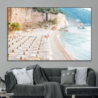 Wall art of a calm Mediterranean beach with rows of sun loungers and umbrellas in soft pastel tones, perfect for light coastal or vacation-themed decor.