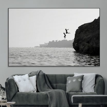 Black and white canvas of two figures cliff jumping into the sea, captured with moody tones, ideal for modern coastal or adventure-themed home decor.   2/2