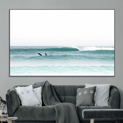 Minimalist photo of a lone surfer on calm aqua waves under bright sky, perfect for Scandinavian coastal or serene ocean-inspired home decor.