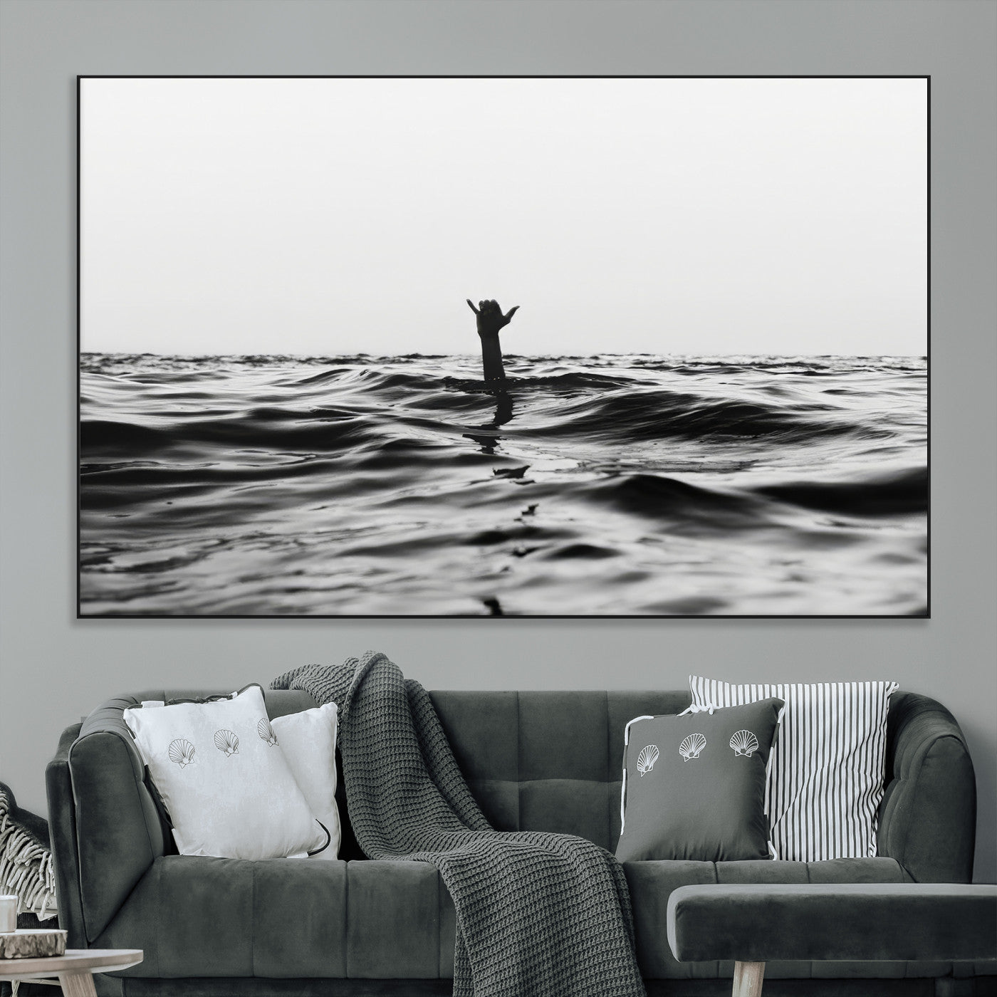 Black and white ocean with a hand making a surfer sign among dark waves, creating a dramatic and minimalist seascape with bold contrast.
