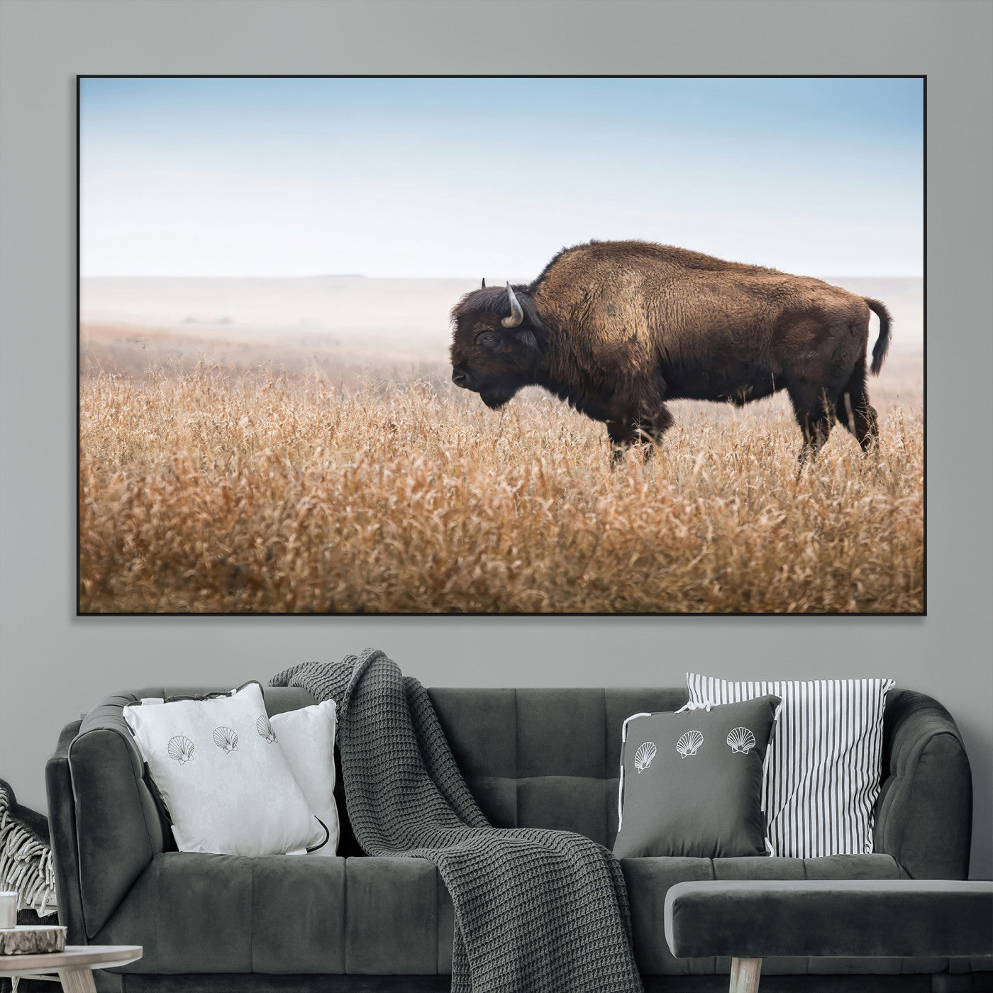 A majestic bison standing in an open prairie field, its strong form blending into the golden grass under a vast blue sky, evoking the wild spirit of the American plains.