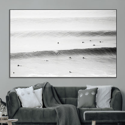 A monochrome photograph of swimmers gliding through gentle ocean waves, evoking a sense of calm and movement.
