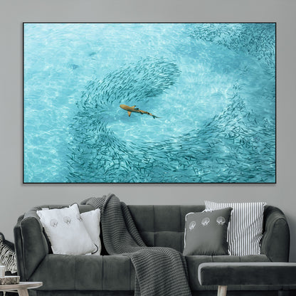 Aerial view of a shark swimming through a swirl of fish in clear turquoise waters, perfect for calm coastal or beach house decor.