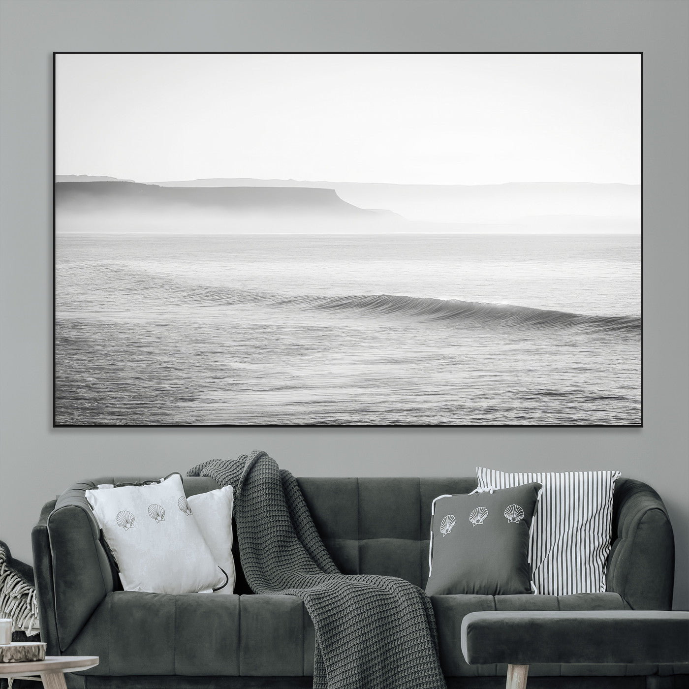 A black and white minimalist seascape featuring soft rolling waves and misty distant cliffs, creating a serene and timeless coastal atmosphere.