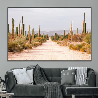 A desert road lined with saguaro cacti under a golden sky, creating a warm southwestern feel, perfect for boho or rustic decor.