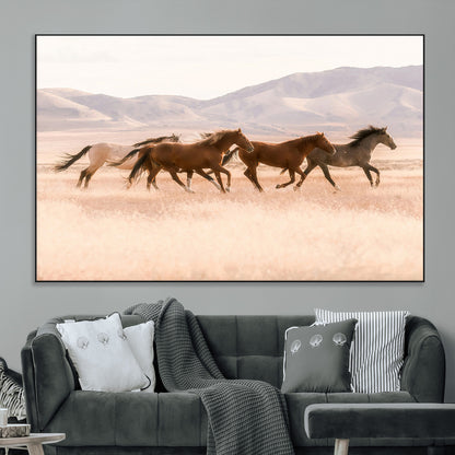 A herd of wild horses galloping through a sunlit desert plain with mountains in the background, perfect for rustic or western-themed wall decor.