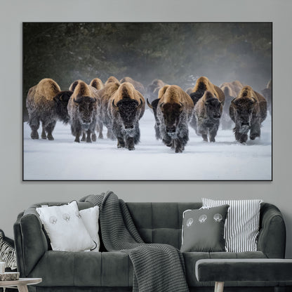 A herd of American bisons walking through deep snow in a forest, evoking a powerful rustic wilderness mood for western-style interiors.