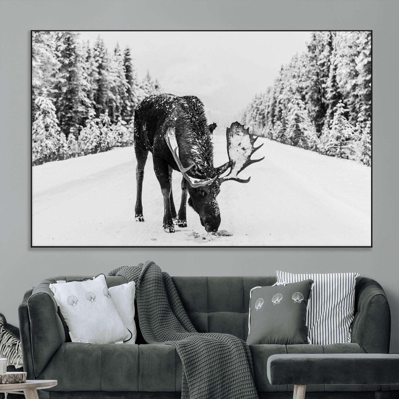 A majestic moose grazing in the snow-covered wilderness, surrounded by snow-covered trees, creating a peaceful winter scene.