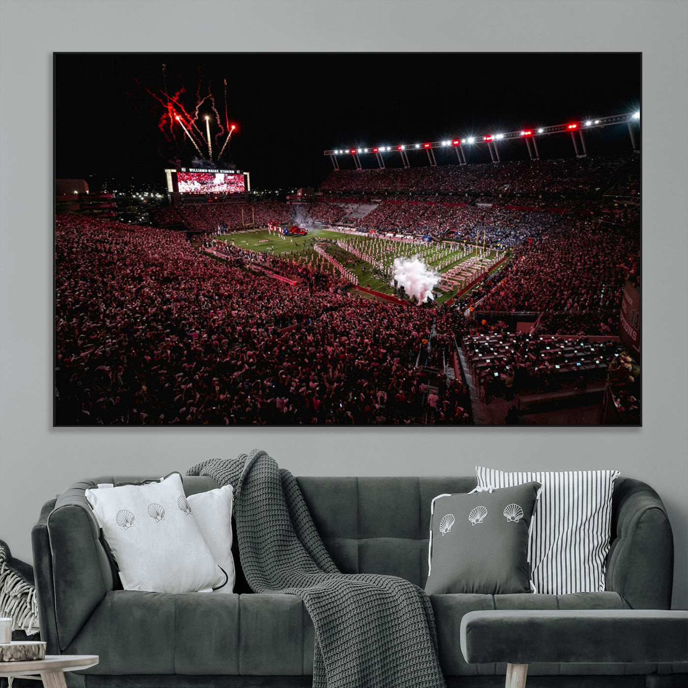 A dramatic shot of a packed stadium at night, with fireworks and smoke creating an exciting atmosphere for a live football game.