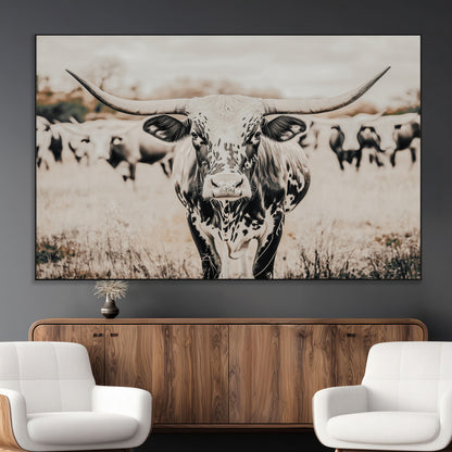 Canvas of a speckled Texas longhorn standing boldly in a field with a herd behind, perfect for rustic western or farmhouse wall decor.