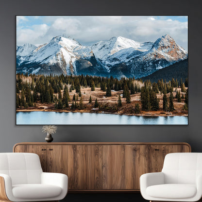 Framed canvas of snowy mountain peaks with pine forest and alpine lake, perfect for winter cabin or wilderness-inspired home decor.