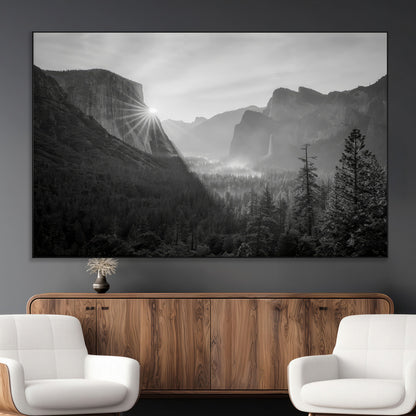 Black and white landscape of Yosemite with sun rays peeking over El Capitan, ideal for moody nature or modern rustic decor.