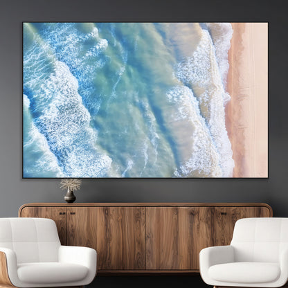 Aerial photo of soft blue waves meeting sandy shore, perfect for modern coastal or beach-themed decor with a light and tranquil aesthetic.