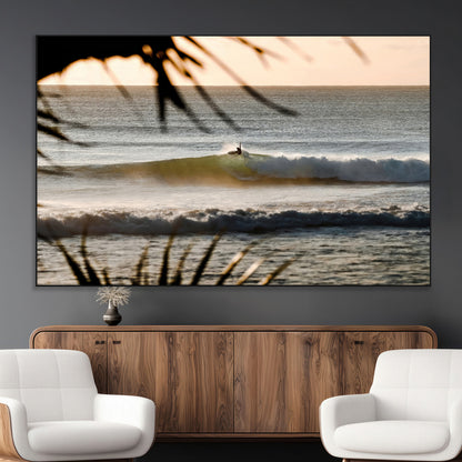 Photo of a surfer riding a golden hour wave at sunset, with tropical tones and dreamy light, perfect for tropical boho or coastal home decor.