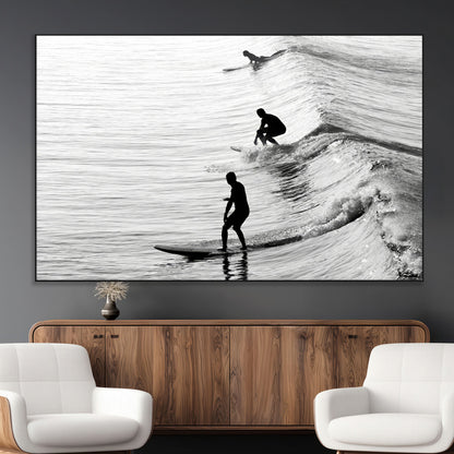 Black and white photo of surfers riding waves in a moody, high-contrast scene, ideal for modern coastal or surf-inspired home decor.