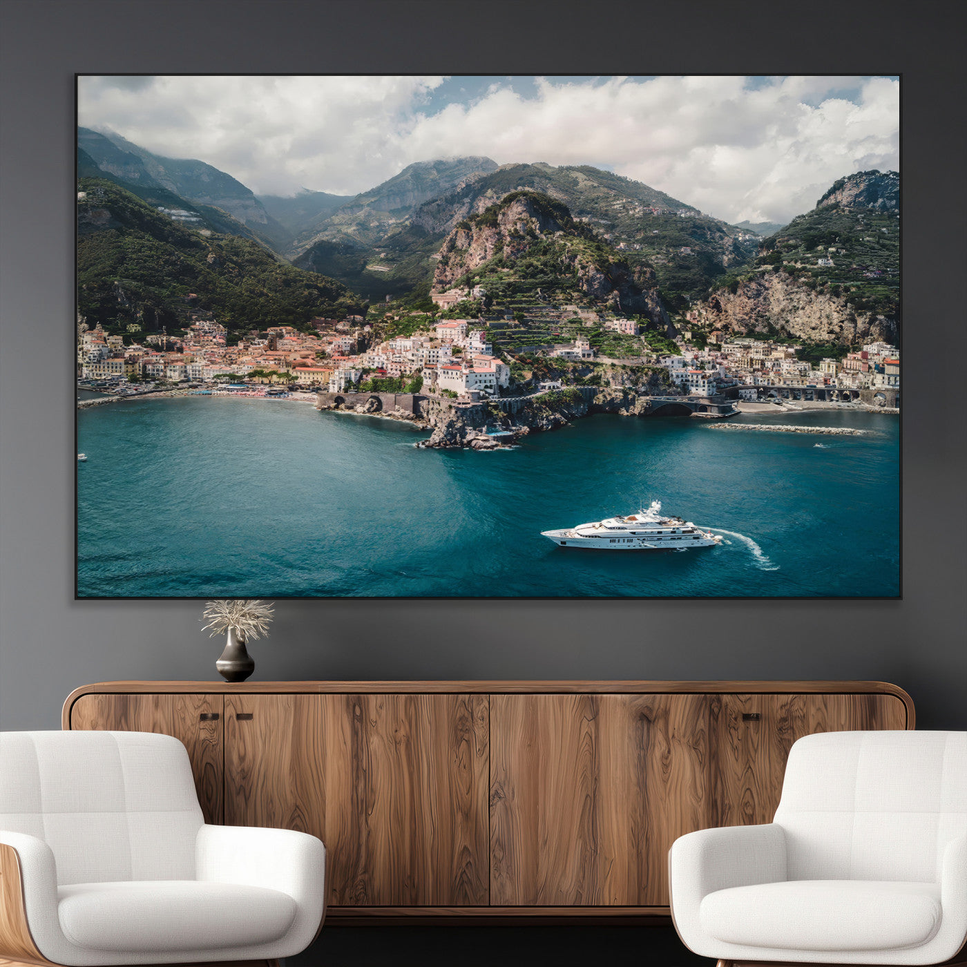 Aerial view of Amalfi Coast, Italy, with colorful hillside houses, lush green mountains, and a luxury yacht sailing in turquoise waters.