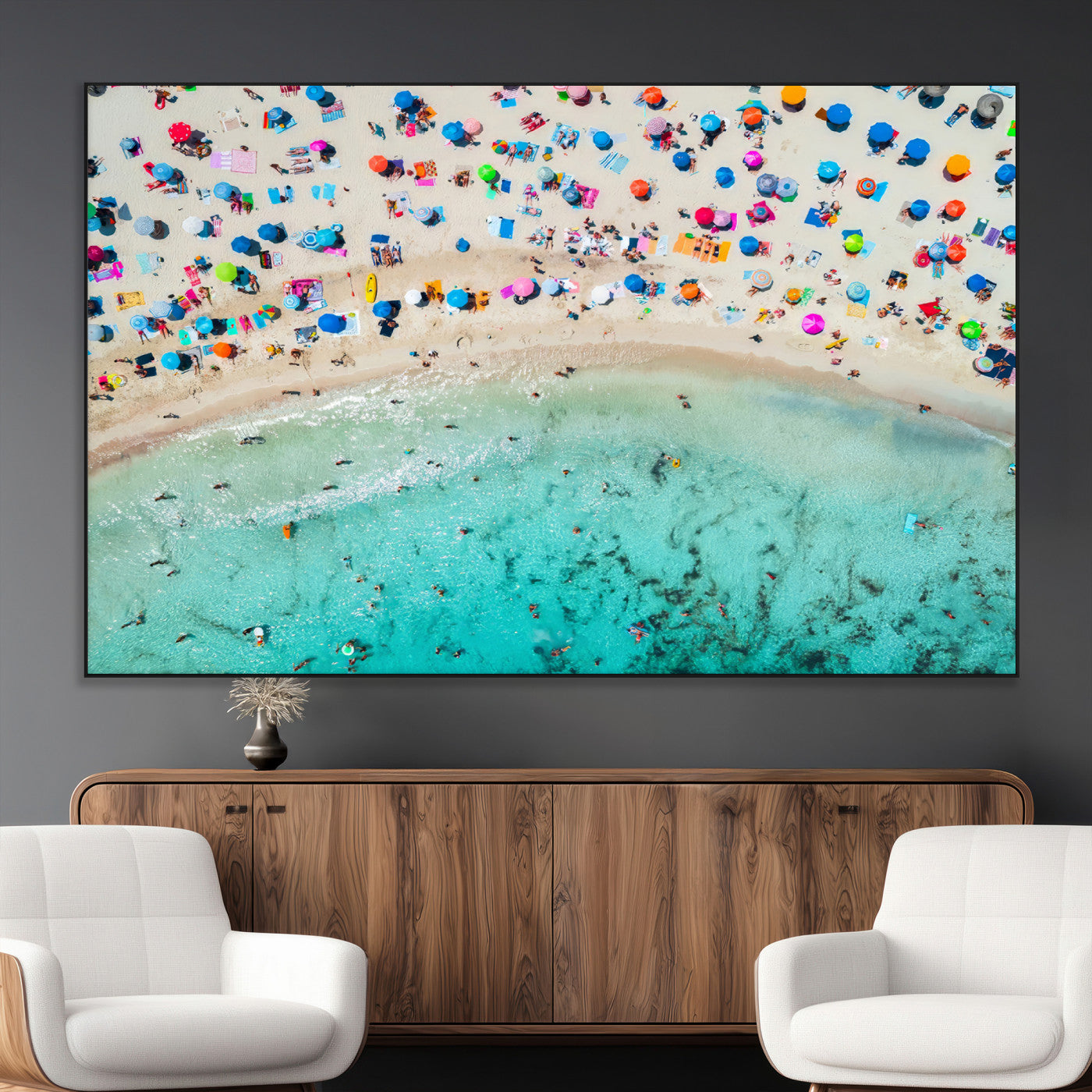 Aerial view of a vibrant beach filled with colorful umbrellas and people enjoying the turquoise ocean, capturing a lively summer vacation scene.