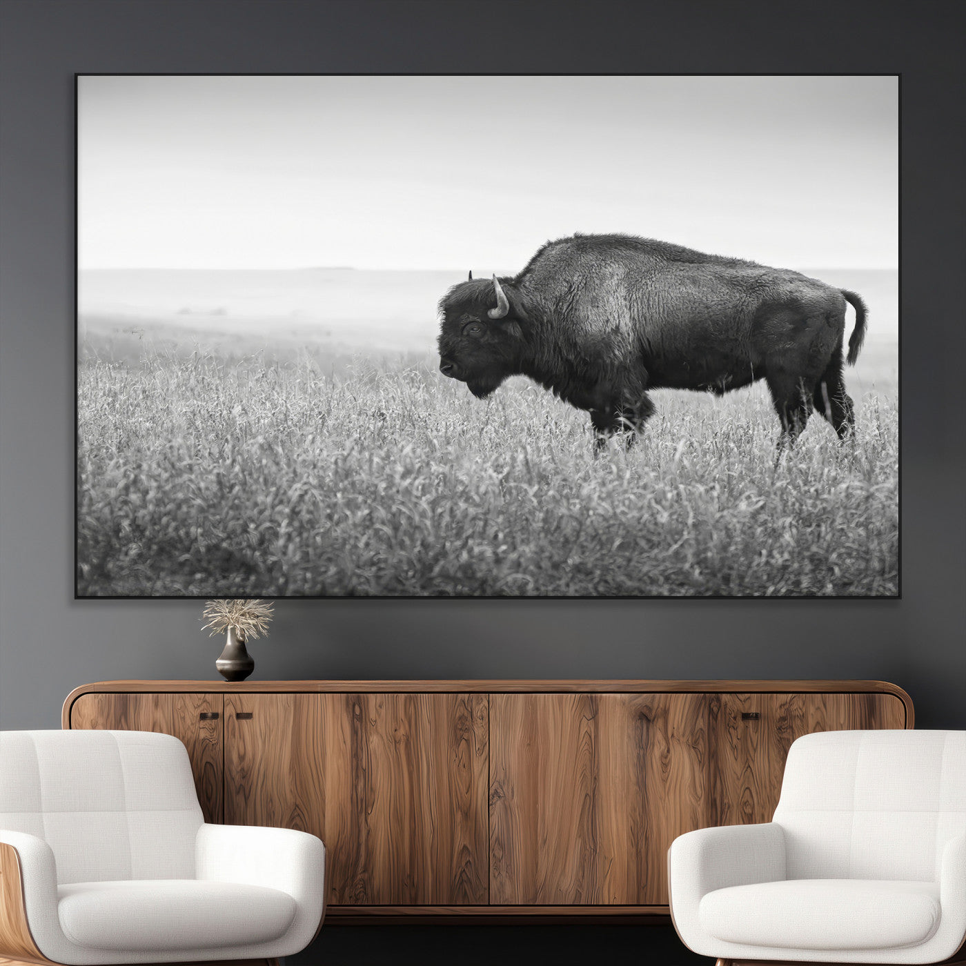 A black and white photograph of a majestic bison standing in a vast grassy prairie, evoking a sense of wilderness and strength.