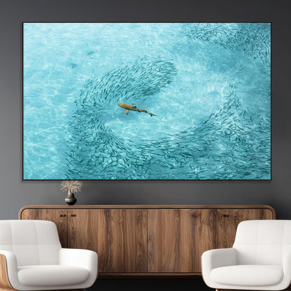 Aerial view of a shark swimming through a swirl of fish in clear turquoise waters, perfect for calm coastal or beach house decor.