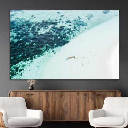 Canvas featuring an aerial view of a swimmer in shallow turquoise waters with coral patterns, ideal for tropical coastal home decor.