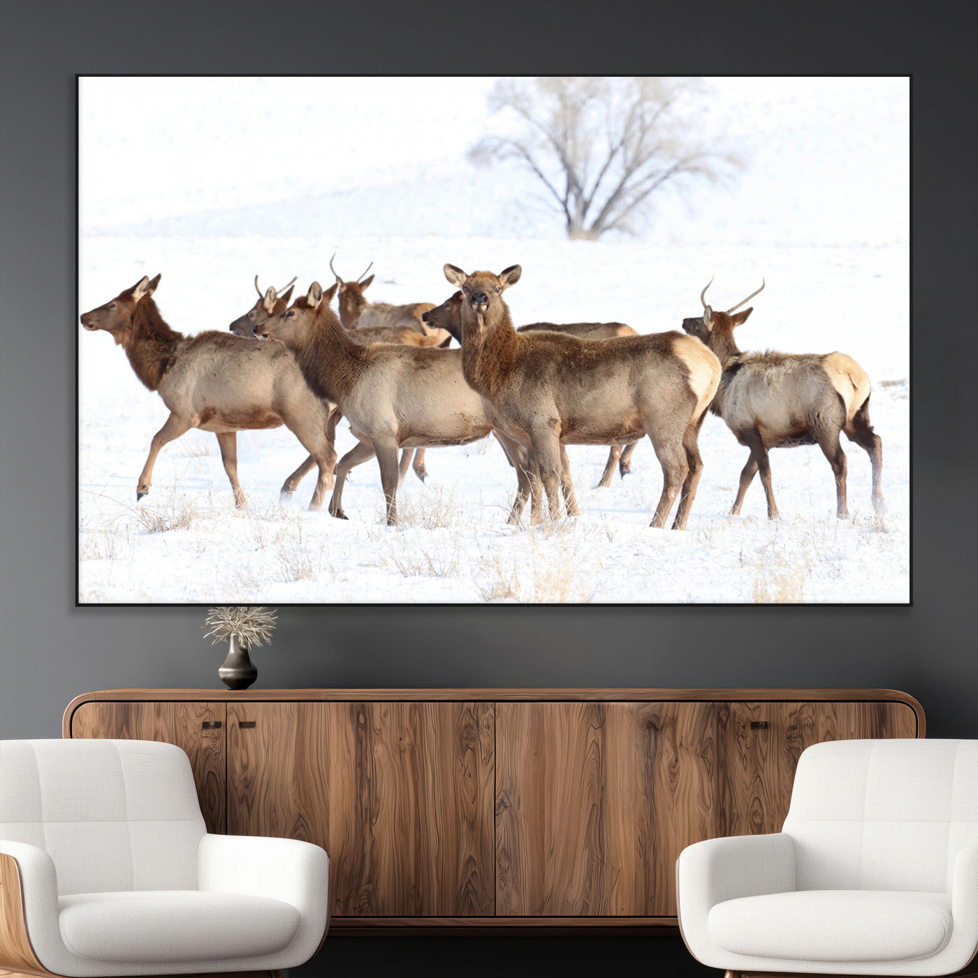 A group of elk standing on snowy terrain with a tree in the background, perfect for rustic or lodge-style winter wall decor.