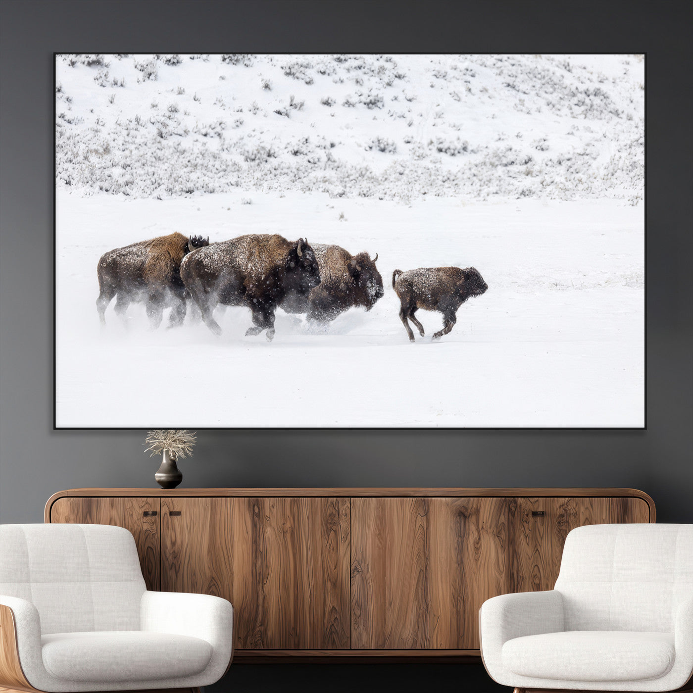 Bison herd running through a snowy open field with mountain backdrop, perfect for rustic or western-themed wall decoration.