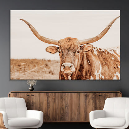 A longhorn bull standing proudly in a sunlit desert field with warm neutral tones, ideal for rustic western or farmhouse interiors.
