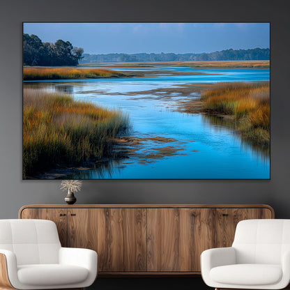 A peaceful marshland scene with calm blue water reflecting the surrounding grasses and trees, capturing the beauty of nature in a serene landscape.