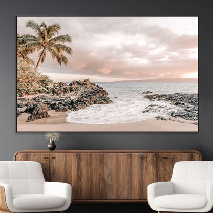 A peaceful beach scene with a palm tree and rocks, soft waves washing onto the shore under a soft pastel sky at sunset.