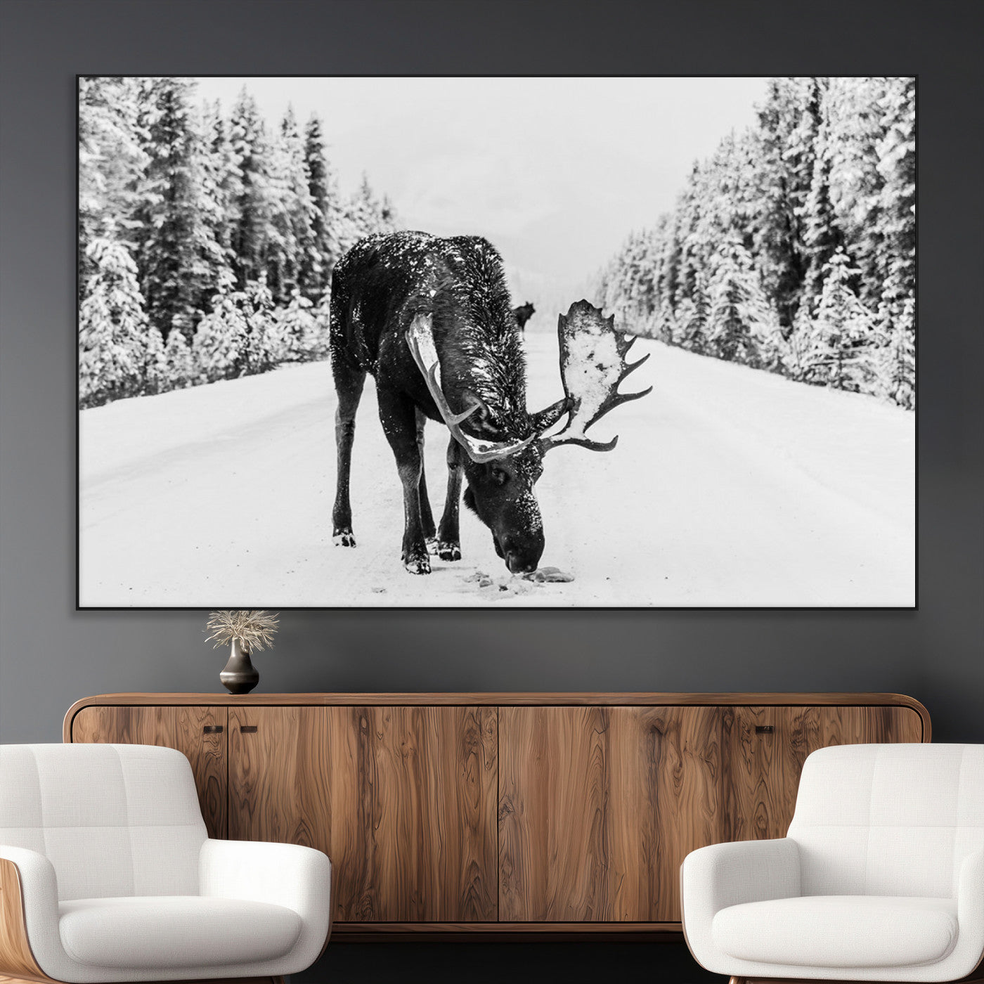 A majestic moose grazing in the snow-covered wilderness, surrounded by snow-covered trees, creating a peaceful winter scene.